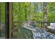 Relaxing outdoor deck surrounded by lush greenery with patterned rug at 2451 Cedar Fork Trl, Marietta, GA 30062