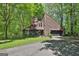 Contemporary home featuring a unique angled roofline, attached garage, and nestled among lush greenery at 2451 Cedar Fork Trl, Marietta, GA 30062