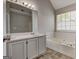 Bathroom featuring a double vanity, tile flooring, soaking tub, and bright natural light at 3612 River Mill Ct, Ellenwood, GA 30294