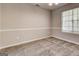 Cozy bedroom with neutral walls, plush carpet, base molding, and a window for natural light at 3612 River Mill Ct, Ellenwood, GA 30294