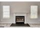 A beautiful fireplace with white mantle and stone hearth between bright windows at 3612 River Mill Ct, Ellenwood, GA 30294
