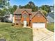 Brick two story house featuring a two car garage and manicured lawn at 3612 River Mill Ct, Ellenwood, GA 30294