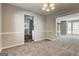 Open-concept living room showcasing neutral paint, plush carpeting, and a view into the kitchen and front entrance at 3612 River Mill Ct, Ellenwood, GA 30294