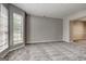 Living room featuring neutral walls, carpet, and large window for ample light at 3612 River Mill Ct, Ellenwood, GA 30294