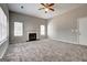 Open living room featuring a fireplace, ceiling fan, and bright windows at 3612 River Mill Ct, Ellenwood, GA 30294