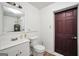 This bathroom features a white vanity, toilet, and a wood-look floor at 736 Stagecoach Rd, Stockbridge, GA 30281