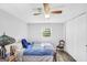 Bright bedroom featuring wood floors, a ceiling fan, two windows, and a large wardrobe at 736 Stagecoach Rd, Stockbridge, GA 30281