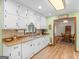 Bright kitchen featuring white cabinets, wood countertops, stainless steel sink, dishwasher, and tile backsplash at 121 Cotton Indian Trl, Stockbridge, GA 30281