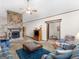 A cozy living room featuring a stone fireplace, ceiling fan, and open access to other areas at 121 Cotton Indian Trl, Stockbridge, GA 30281