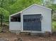 Outbuilding shed with a garage door and large covered porch at 121 Cotton Indian Trl, Stockbridge, GA 30281
