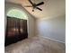 Well-lit bedroom featuring neutral carpet, a ceiling fan, and a large window with decorative curtains at 10119 Commons Way, Jonesboro, GA 30238