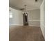 Dining area with plush carpet, decorative chandelier and a view of the hall area with neutral decor at 10119 Commons Way, Jonesboro, GA 30238