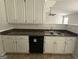 Well-lit kitchen featuring white cabinets, dark countertops, and stainless steel sink at 10119 Commons Way, Jonesboro, GA 30238