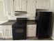 Functional kitchen includes white cabinets, black appliances, and dark granite countertops at 10119 Commons Way, Jonesboro, GA 30238