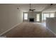 Spacious living room featuring plush carpet, ceiling fan, fireplace, and large windows for natural light at 10119 Commons Way, Jonesboro, GA 30238