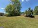 Yard with mature trees and a glimpse of the house at 10119 Commons Way, Jonesboro, GA 30238