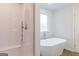 Bathroom featuring a walk-in tiled shower and a soaking tub next to a window at 5318 Tolar Rd # 25, South Fulton, GA 30213
