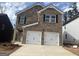 Two-story brick home with a two-car garage and a well-manicured lawn under a blue sky at 5318 Tolar Rd # 25, South Fulton, GA 30213