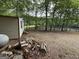 Backyard area next to shed with stacked wood and lake view beyond trees at 191 Tumlin Creek Rd # 1, Roopville, GA 30170