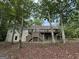 Beautiful two-story house with wooden stairs leading to a large backyard deck, surrounded by trees at 191 Tumlin Creek Rd # 1, Roopville, GA 30170