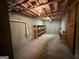 Unfinished basement featuring exposed ceiling beams, wooden shelves, and ample space for customization at 191 Tumlin Creek Rd # 1, Roopville, GA 30170