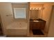 Bathroom featuring a soaking tub, vanity with a black countertop, and natural light from the window at 191 Tumlin Creek Rd # 1, Roopville, GA 30170