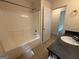 Bright bathroom featuring a shower-tub combo, a dark countertop vanity, and tile flooring at 191 Tumlin Creek Rd # 1, Roopville, GA 30170