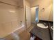 Bathroom showcasing shower-tub combo, single sink vanity and open doorway at 191 Tumlin Creek Rd # 1, Roopville, GA 30170