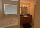 Bathroom featuring a soaking tub, single sink vanity, and neutral color scheme at 191 Tumlin Creek Rd # 1, Roopville, GA 30170