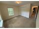 Bedroom with carpet, window, closet, and door to adjacent room providing ample space for comfort and relaxation at 191 Tumlin Creek Rd # 1, Roopville, GA 30170