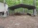 Metal carport with piles of wood and debris at 191 Tumlin Creek Rd # 1, Roopville, GA 30170