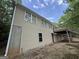 Home exterior, with a deck, stairs, and access to the basement, surrounded by foliage at 191 Tumlin Creek Rd # 1, Roopville, GA 30170