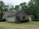 Charming home with a garage and additional building, nestled among lush greenery in a tranquil setting at 191 Tumlin Creek Rd # 1, Roopville, GA 30170