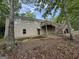 Back of home with a two-story deck and stairs amid mature trees at 191 Tumlin Creek Rd # 1, Roopville, GA 30170