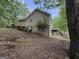 View of the side of the home with wood siding and a walk-out deck area at 191 Tumlin Creek Rd # 1, Roopville, GA 30170