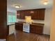 Well-lit kitchen with wooden cabinets, a white stove, and hardwood floors, offering a functional cooking space at 191 Tumlin Creek Rd # 1, Roopville, GA 30170