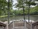 Scenic lake view framed by trees and a wooden deck with railings at 191 Tumlin Creek Rd # 1, Roopville, GA 30170