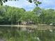 Scenic view of a tranquil pond reflecting the house surrounded by lush trees at 191 Tumlin Creek Rd # 1, Roopville, GA 30170