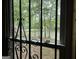 Window view with decorative bars, overlooking the deck and a tranquil lake surrounded by trees at 191 Tumlin Creek Rd # 1, Roopville, GA 30170