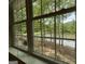 A beautiful view of the lake and surrounding nature is seen through a large window at 191 Tumlin Creek Rd # 1, Roopville, GA 30170