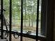A window with black iron bars offers a scenic view of the tranquil lake framed by lush green trees at 191 Tumlin Creek Rd # 1, Roopville, GA 30170