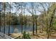 A tranquil lake view is framed by trees, providing a beautiful backdrop for this home at 9055 Carroll Manor Dr, Sandy Springs, GA 30350