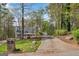 Exterior shot of home with a long driveway and surrounding mature trees at 9055 Carroll Manor Dr, Sandy Springs, GA 30350