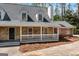 Charming home with a stone facade, dormer windows, and a welcoming front porch at 9055 Carroll Manor Dr, Sandy Springs, GA 30350