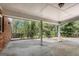 Covered outdoor patio with brick accents, offering a serene view of the wooded backyard and surrounding greenery at 9055 Carroll Manor Dr, Sandy Springs, GA 30350