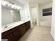 Well-lit bathroom with double sink vanity, and a view into the en-suite with soaking tub and toilet at 2517 Oakleaf Rdg, Lithonia, GA 30058