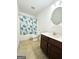 Well-lit bathroom featuring a vanity with sink, toilet, and shower/tub with leafy green shower curtain at 2517 Oakleaf Rdg, Lithonia, GA 30058