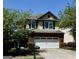 Charming two-story home features a red brick facade with a two-car garage and a well-manicured lawn at 2517 Oakleaf Rdg, Lithonia, GA 30058