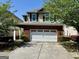 Charming two-story home features a red brick facade with a two-car garage and a well-manicured lawn at 2517 Oakleaf Rdg, Lithonia, GA 30058