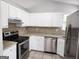 Well-equipped kitchen with stainless steel appliances, granite countertops, tile backsplash and white cabinetry at 4687 Sterling Pointe Ct, Douglasville, GA 30135